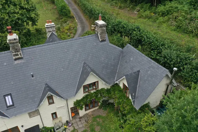 Drone view of a finished natural slate roof on a country cottage