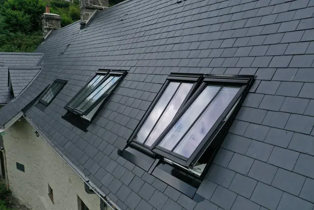 Open VELUX roof windows on a newly slated cottage roof